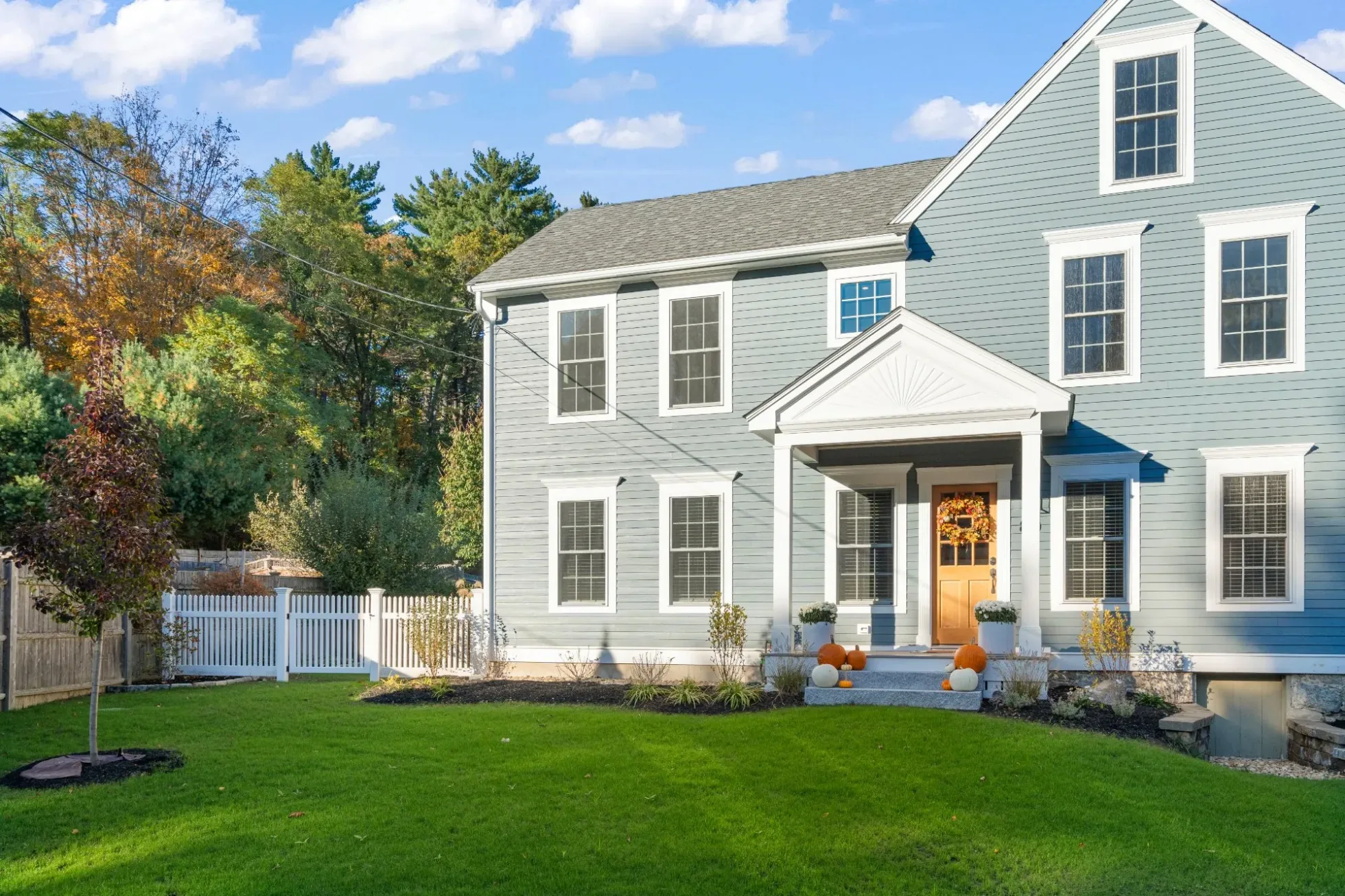 Blue-gray colonial with matched lap siding and a new covered entry after a two-bedroom addition, Amesbury MA