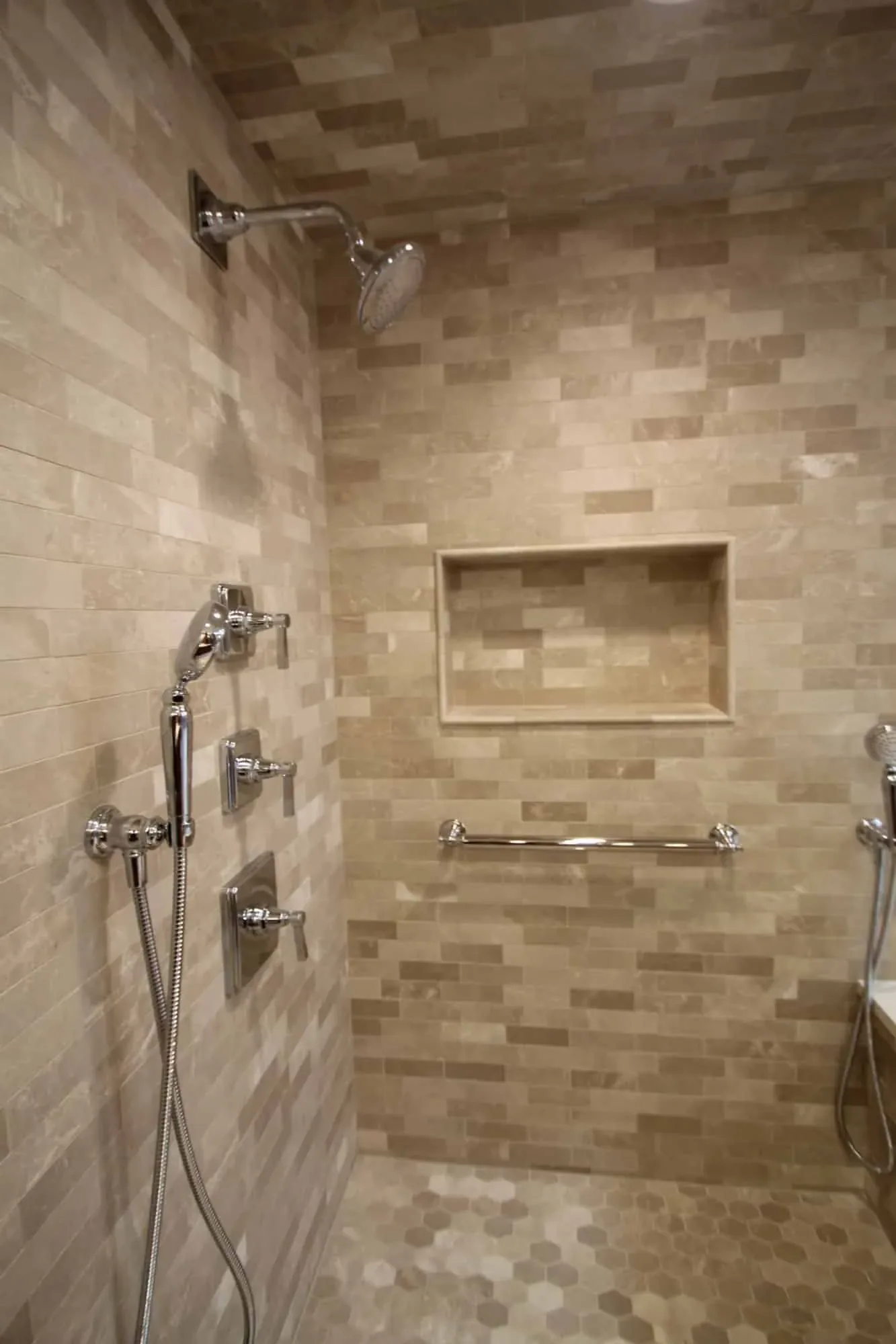 Stone tile shower wall with rain head, handheld spray and a built-in niche, Byfield MA