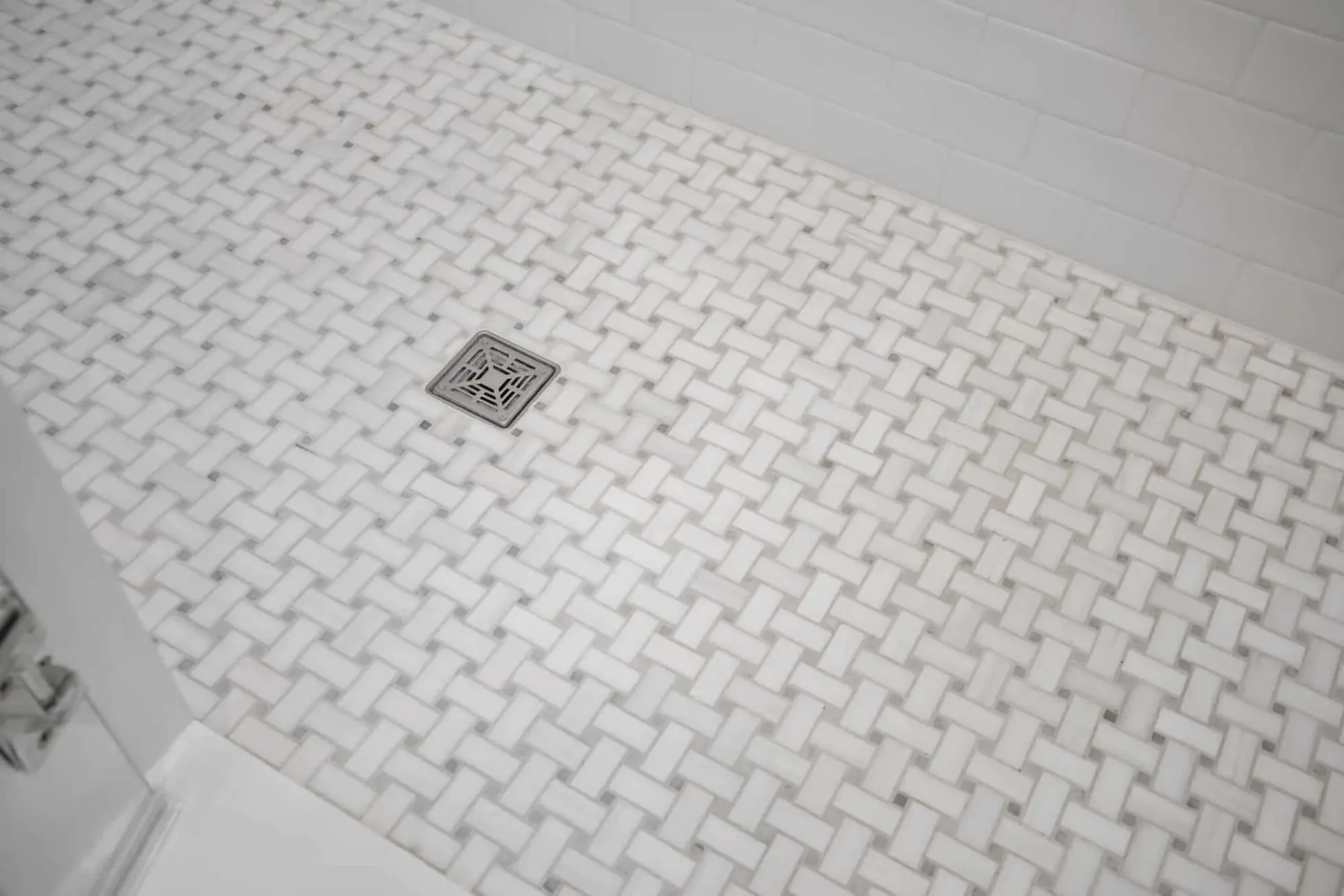 Basketweave mosaic shower floor with a decorative drain