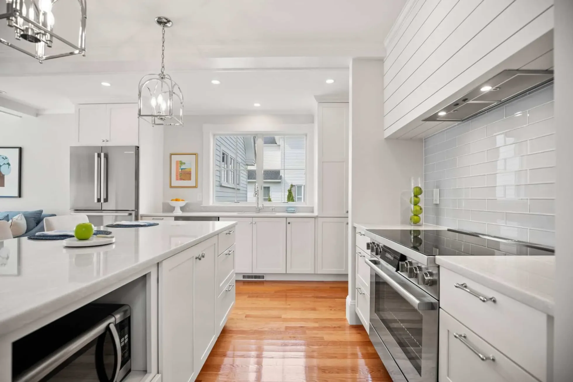 Stainless induction range under a shiplap hood surround with subway tile