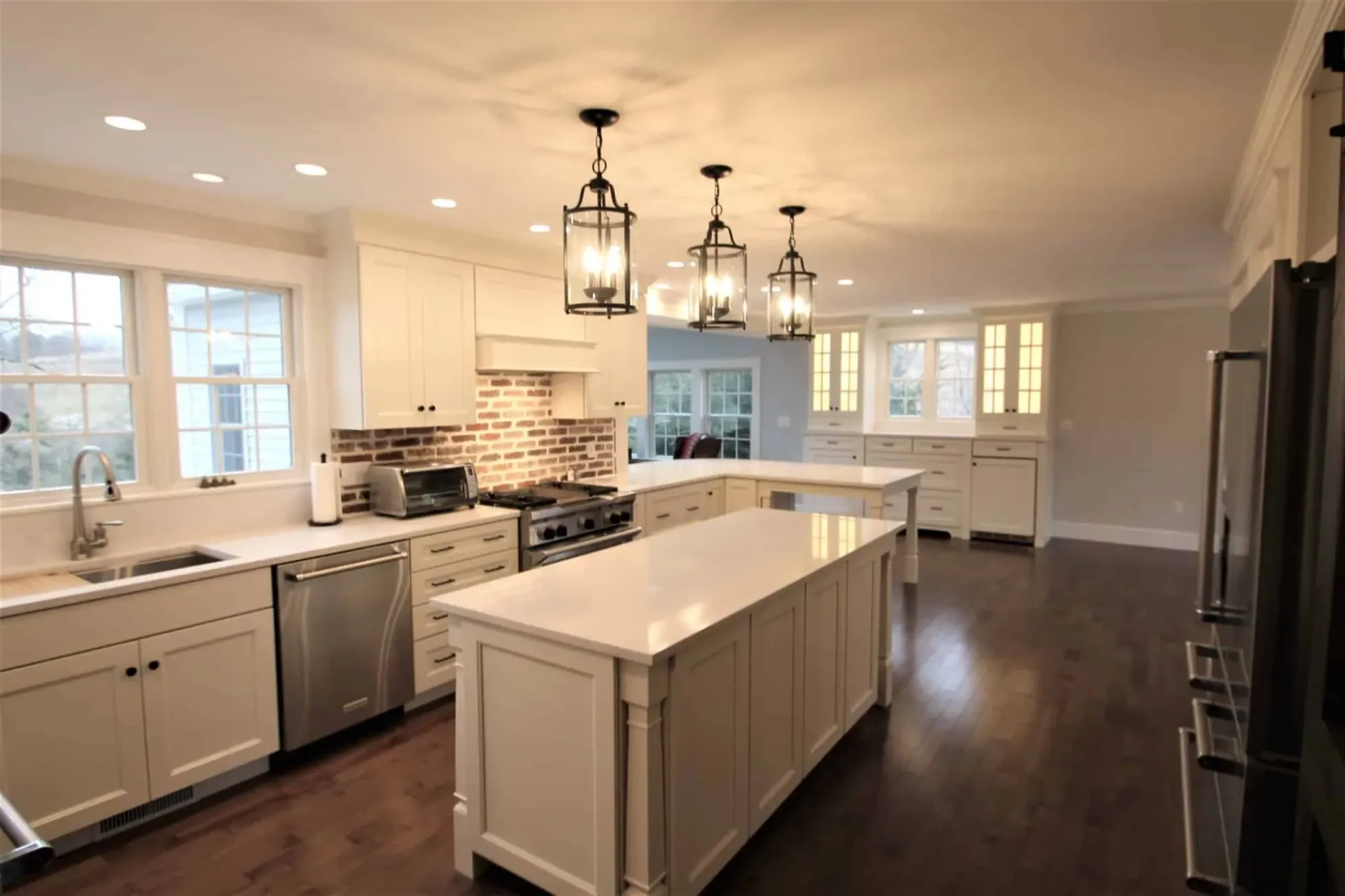 White kitchen with a large center island and lantern pendants, Groveland MA first-floor remodel