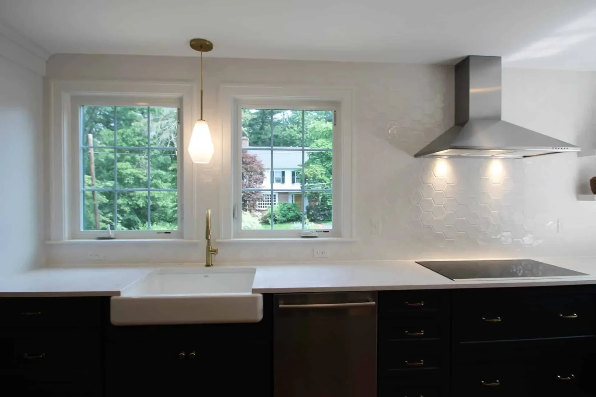 Farmhouse sink between two windows under a full-height white hexagonal tile backsplash, Andover MA kitchen remodel
