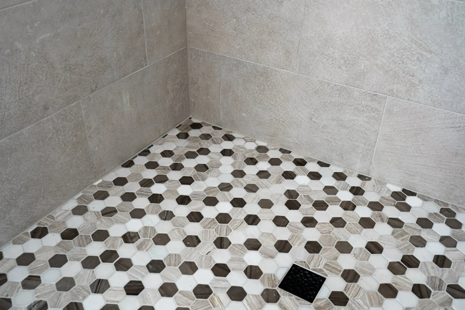 Hexagonal mosaic shower floor tile in brown and white