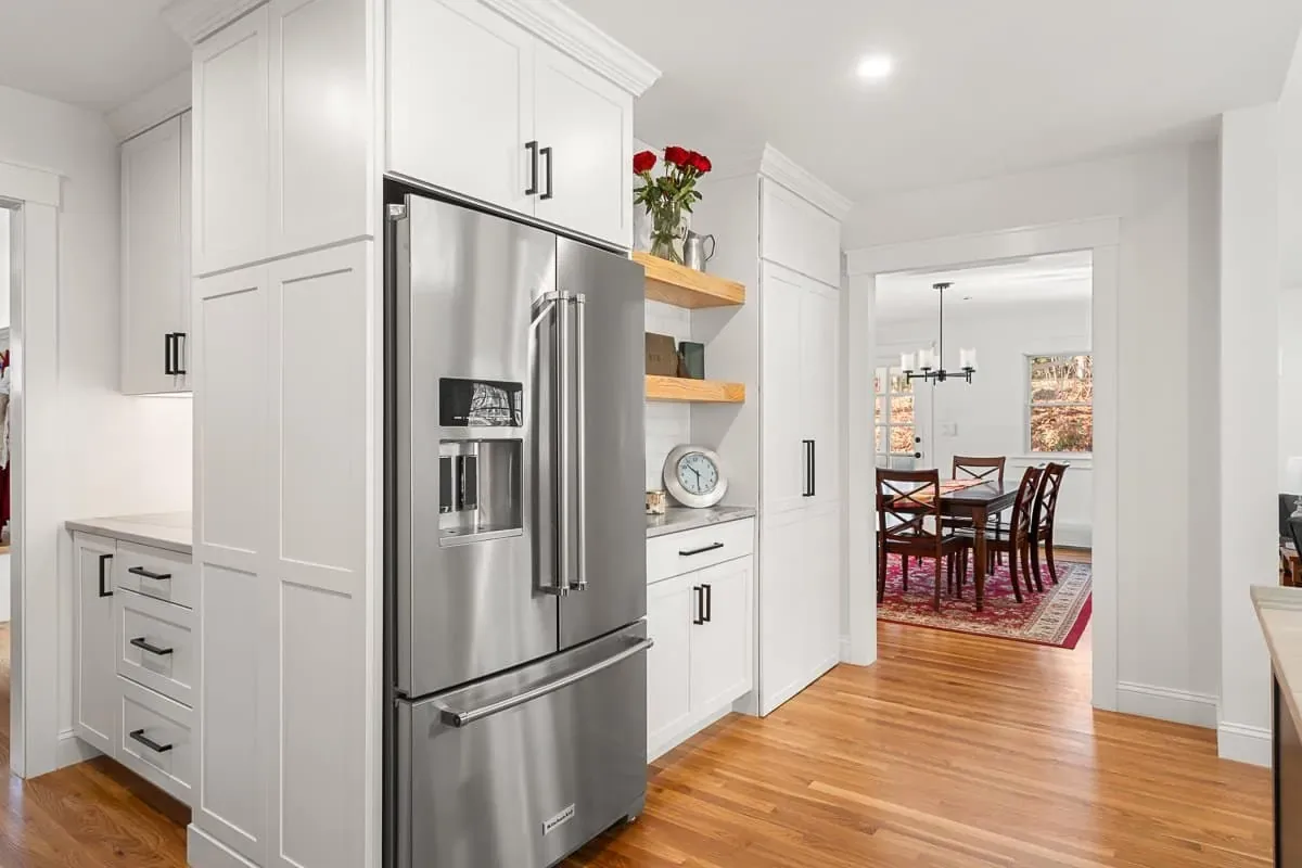 KitchenAid refrigerator in tall white cabinetry with a view to the dining room