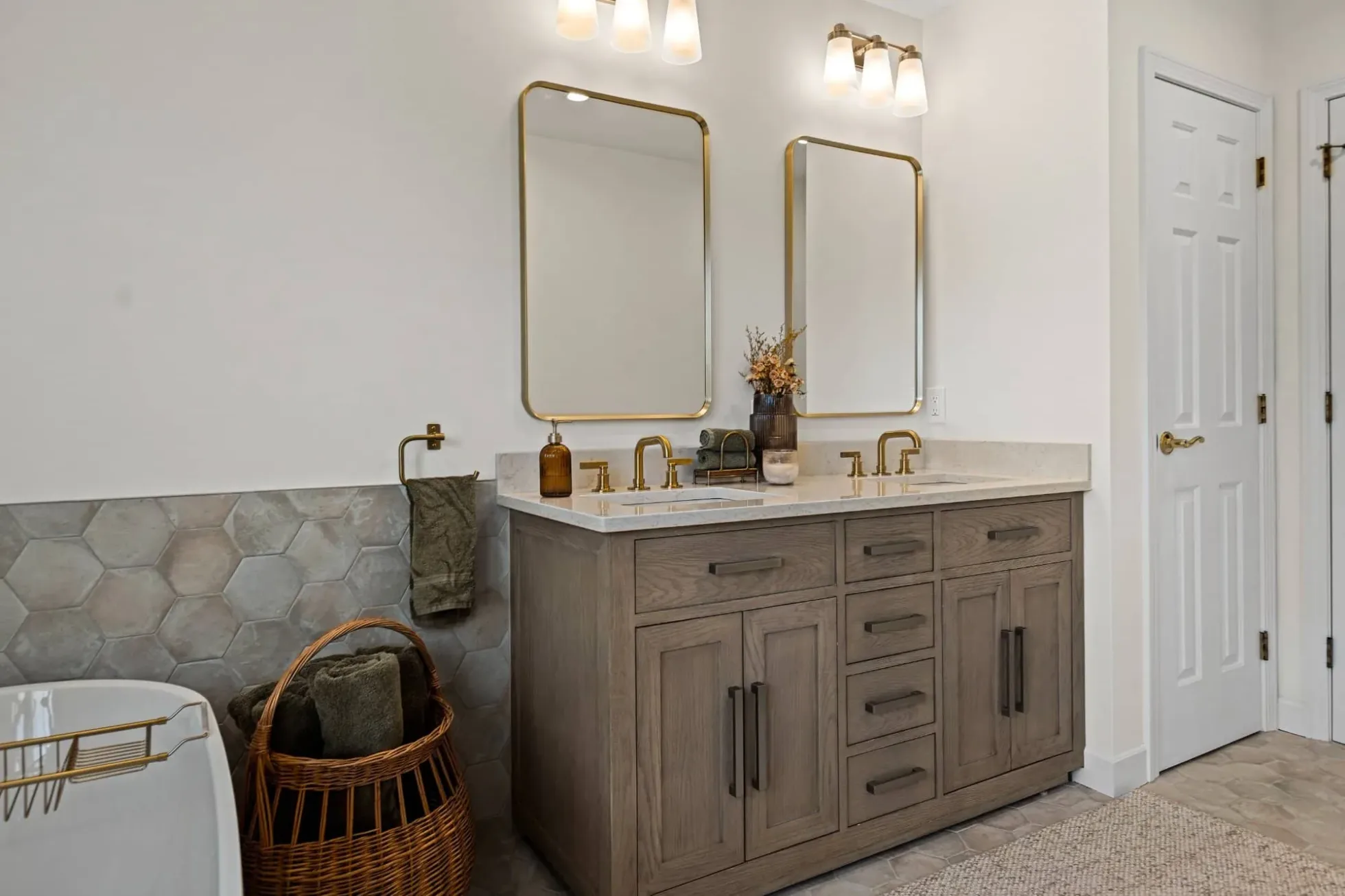 White oak vanity cabinetry with drawers and doors, quartz top and brass mirrors
