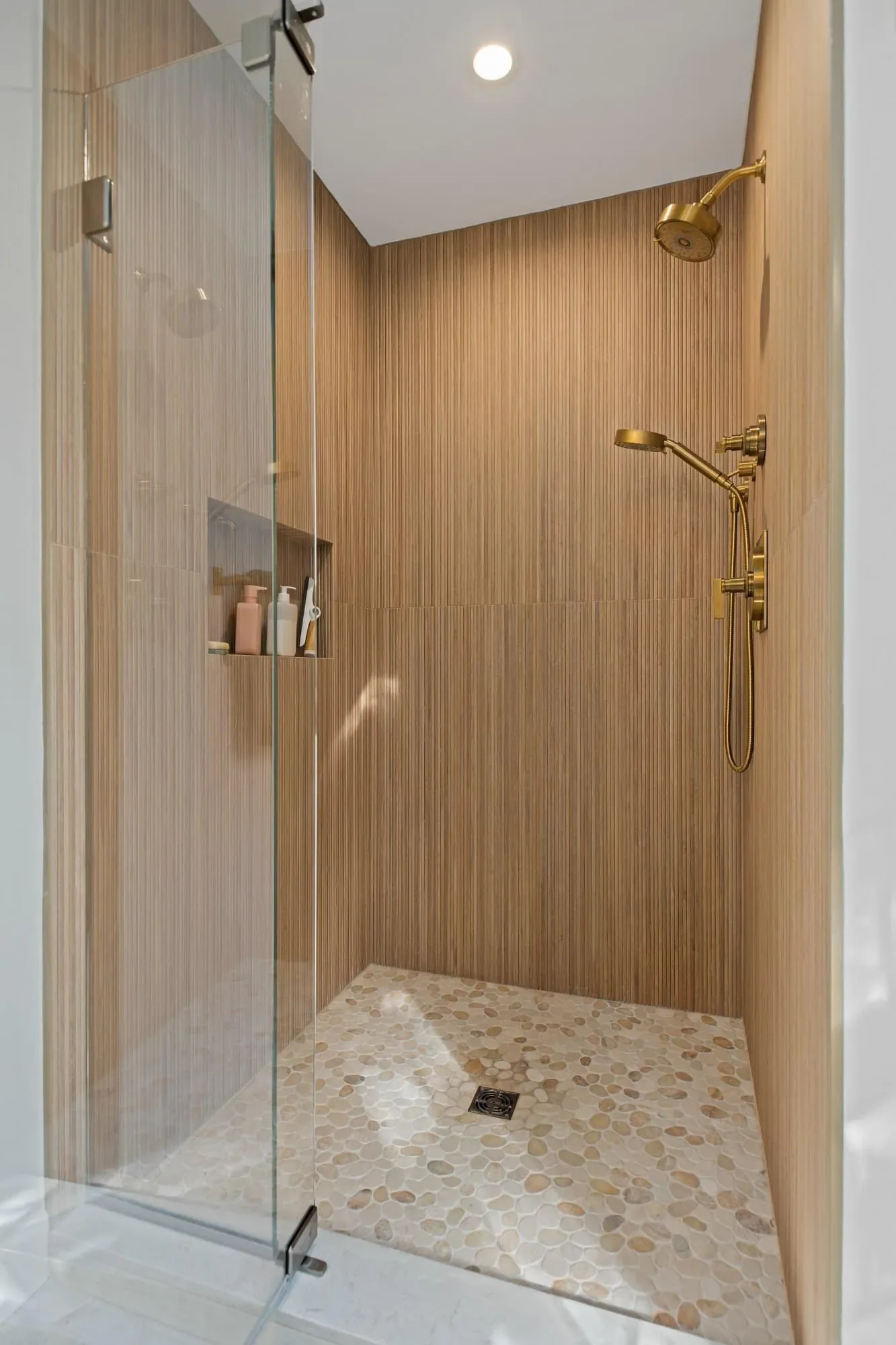 Frameless glass shower door with textured porcelain walls