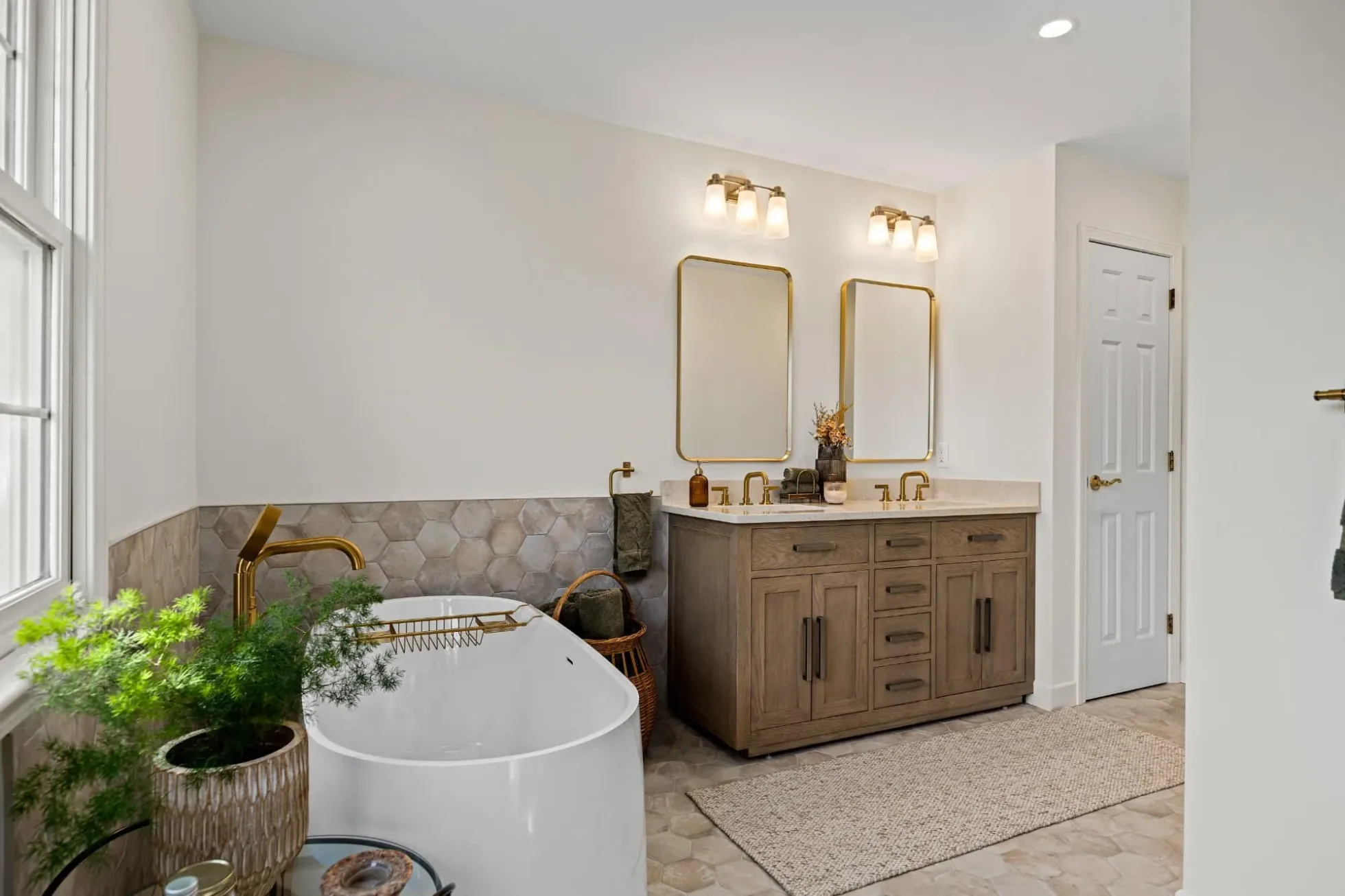 Primary bath with the tub, vanity and textured tile wainscot