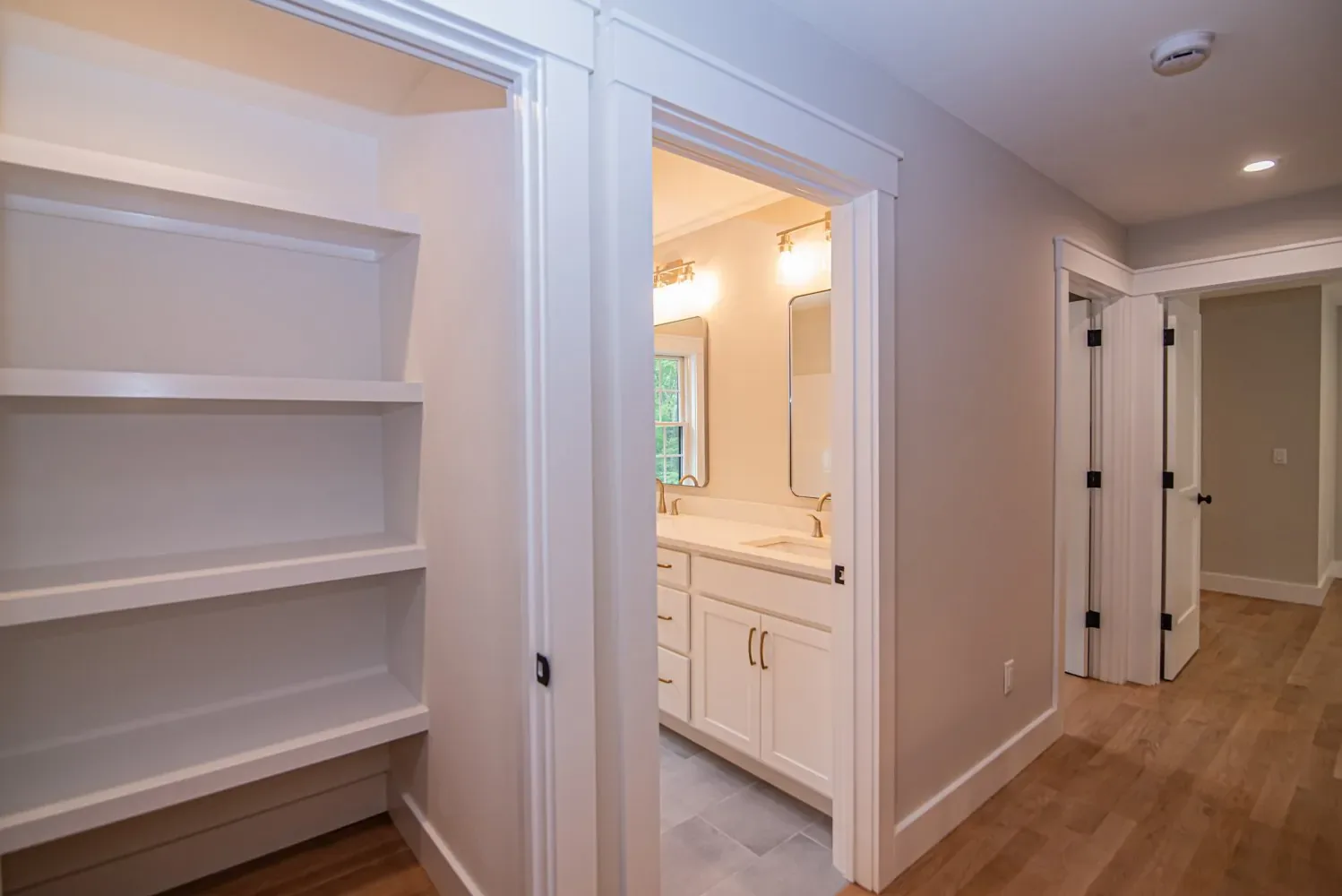 Built-in linen shelving near a bathroom, White Cedar Way custom home, Newton NH