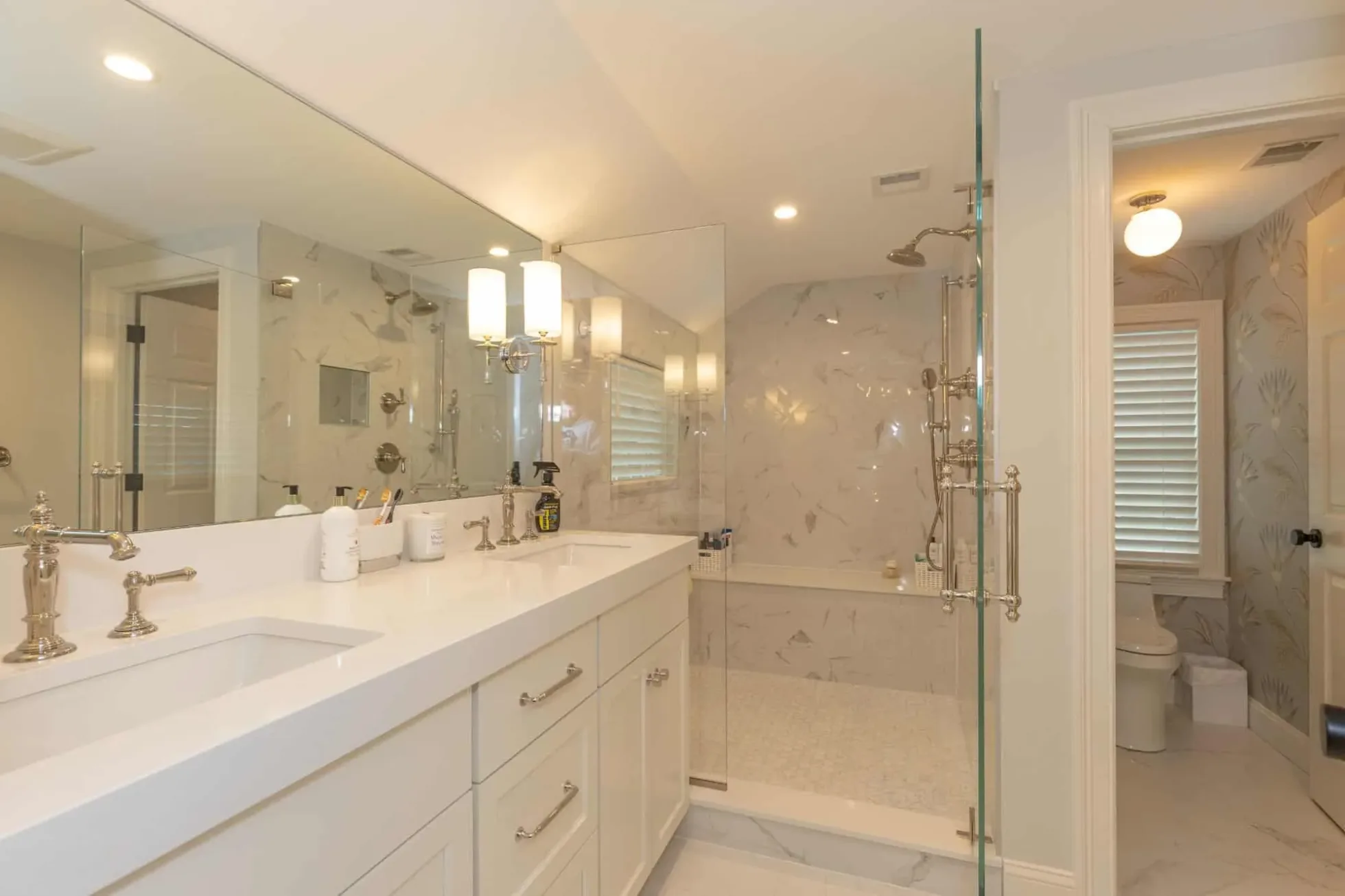 Spa-inspired primary bath with a double vanity and a curbless glass shower