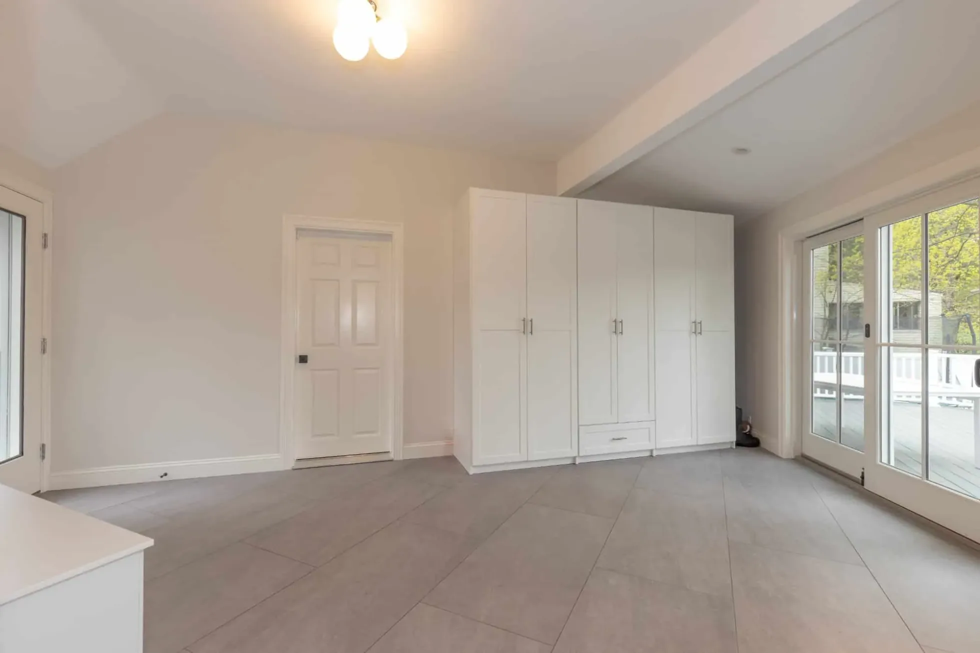 Mudroom with built-in storage cabinetry and large-format porcelain floor tile
